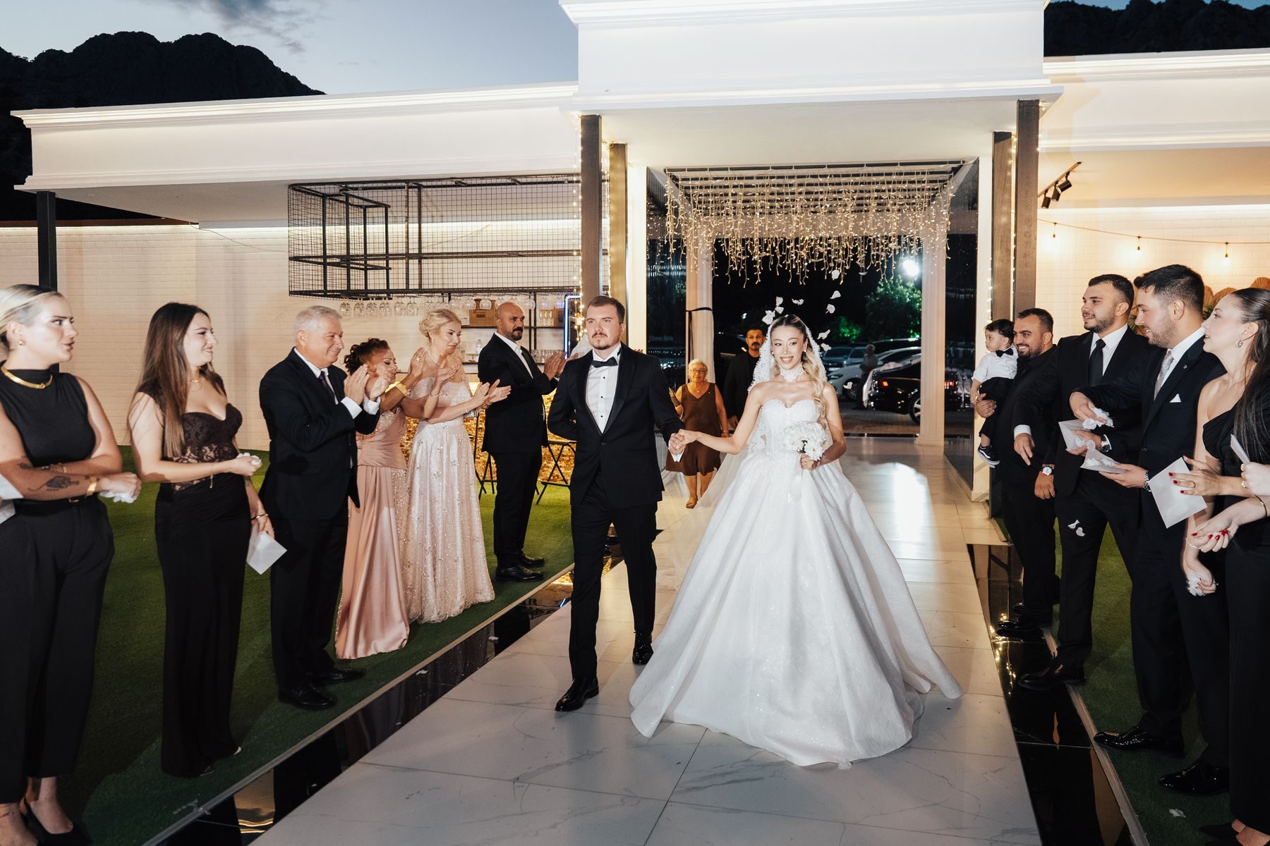 Guests applauding as a newly married couple walks back up the aisle