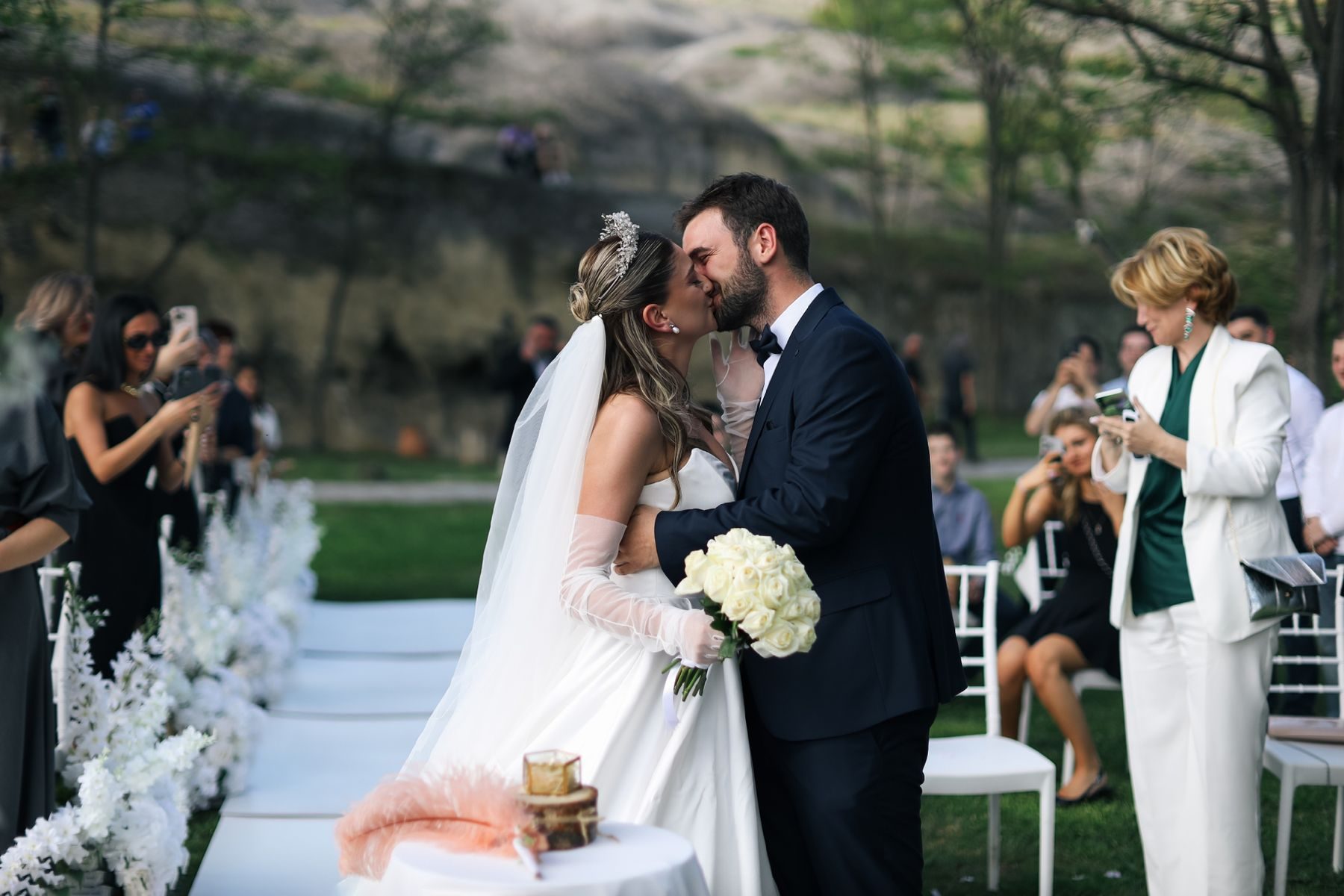 A couple kissing at the end of the aisle