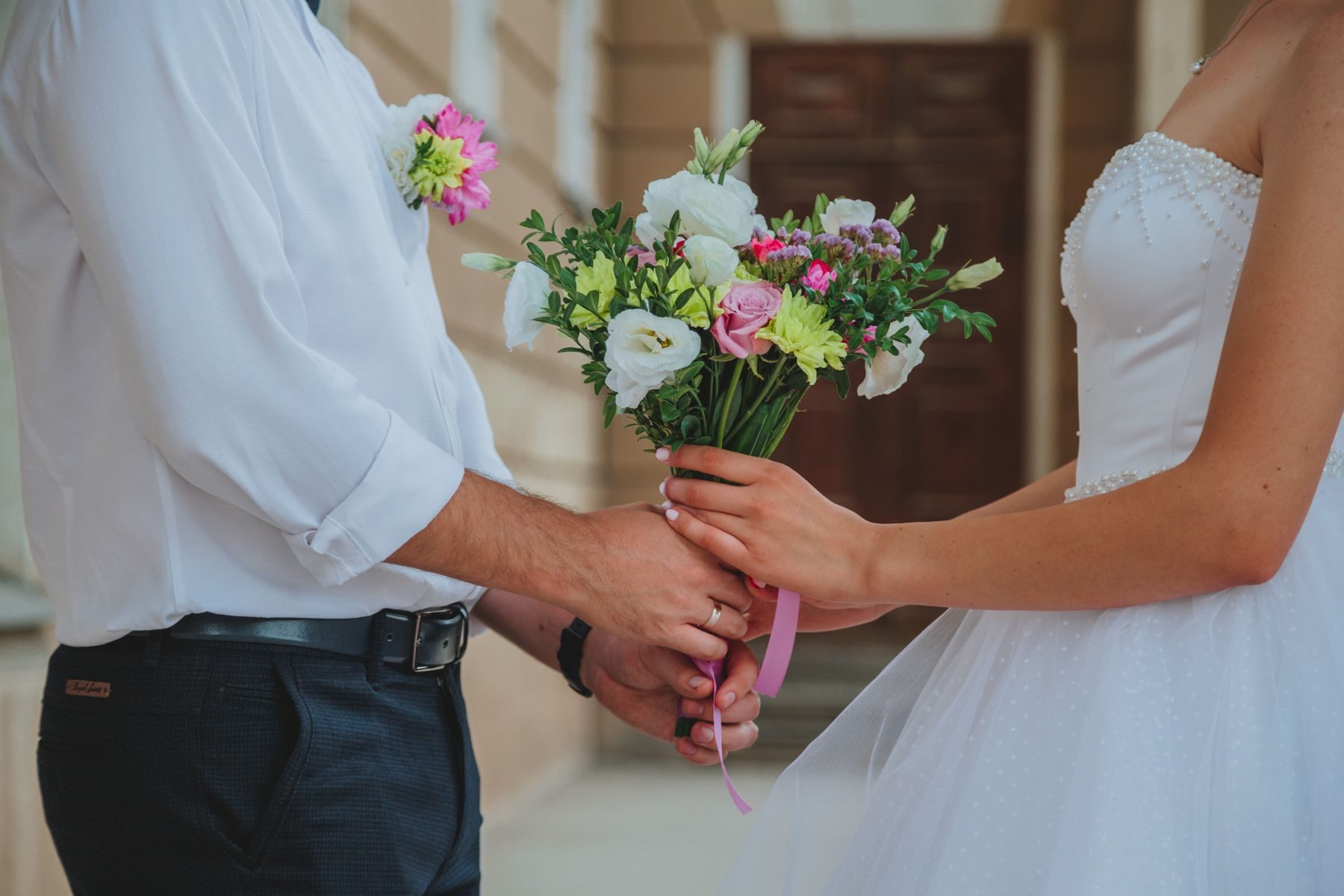A smiling bride holding a bright bouquet