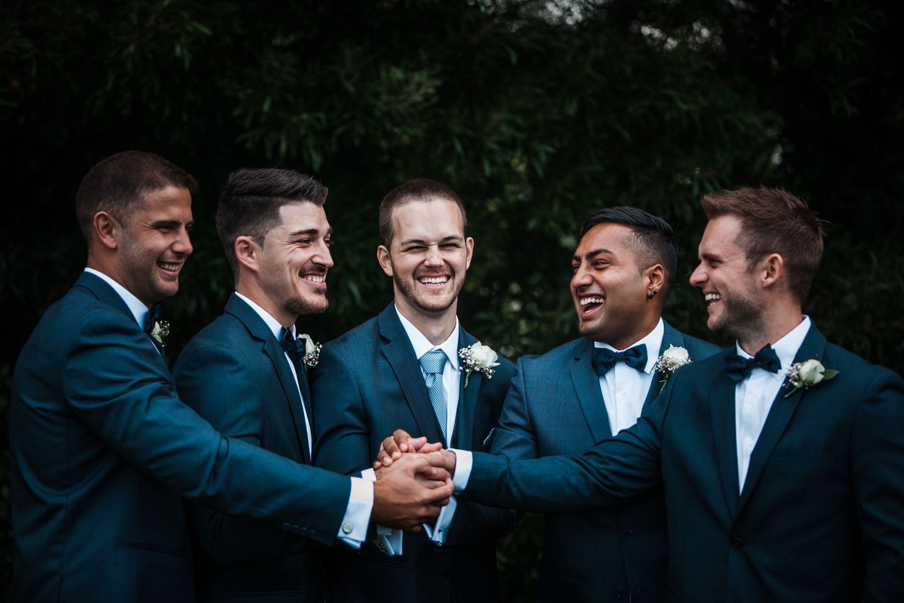 A groom laughing with his groomsmen