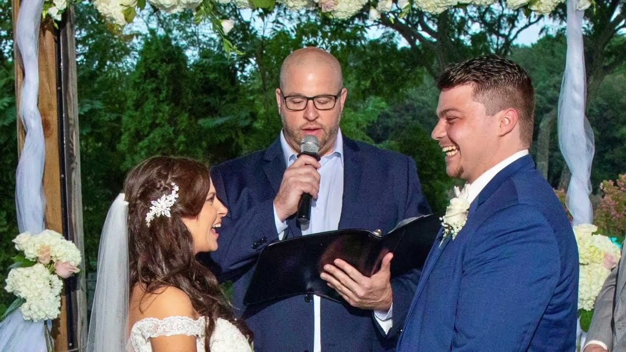 Jim Hill on the mic as a couple laughs through their vows